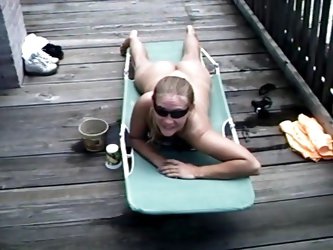 The Hot Blonde Is Sunbathing Naked On A The Deck Near The...